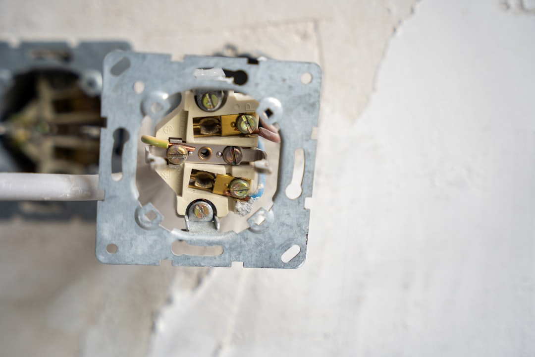 Electrical outlet disassembled, revealing the wiring.