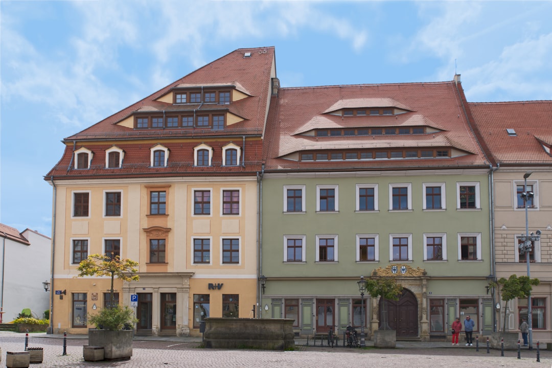 Colorful buildings line a town square with a fountain.