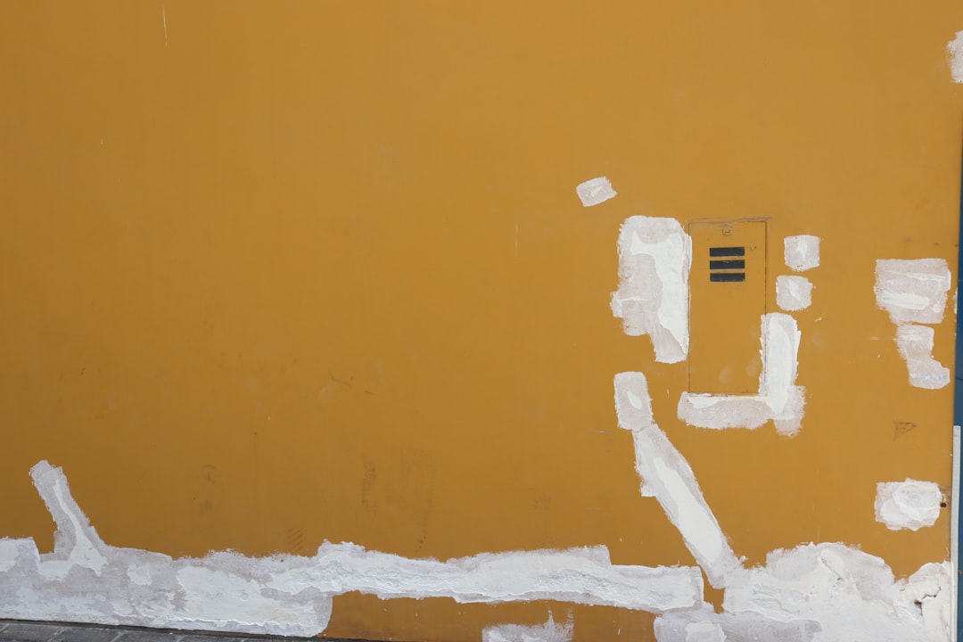 Yellow wall with patches of white plaster repairs