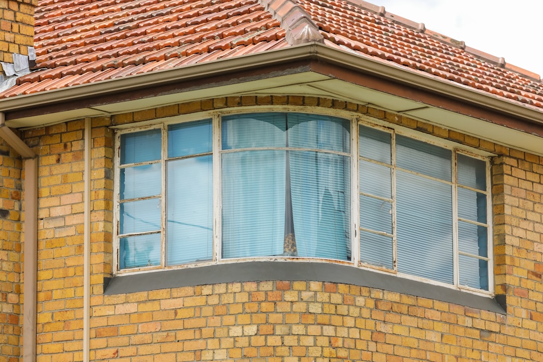 close-up photo of brown concrete house with glass windows during daytime