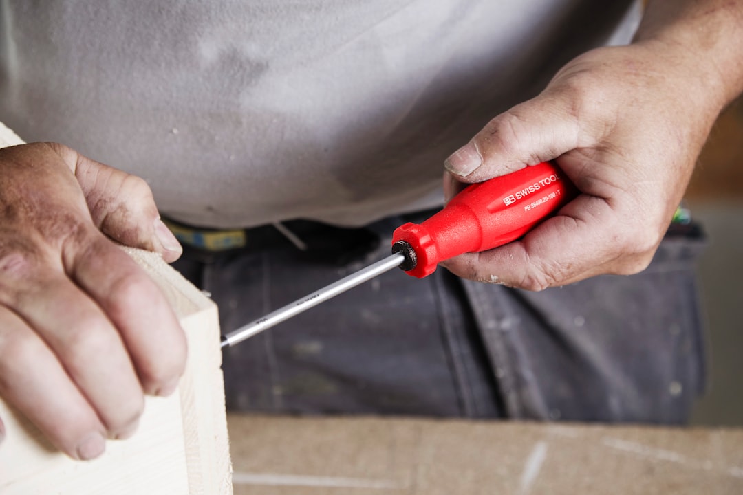A person uses a screwdriver to build.