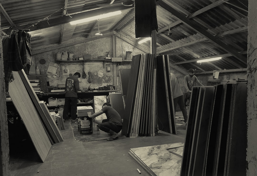Workers in a workshop with stacked materials.