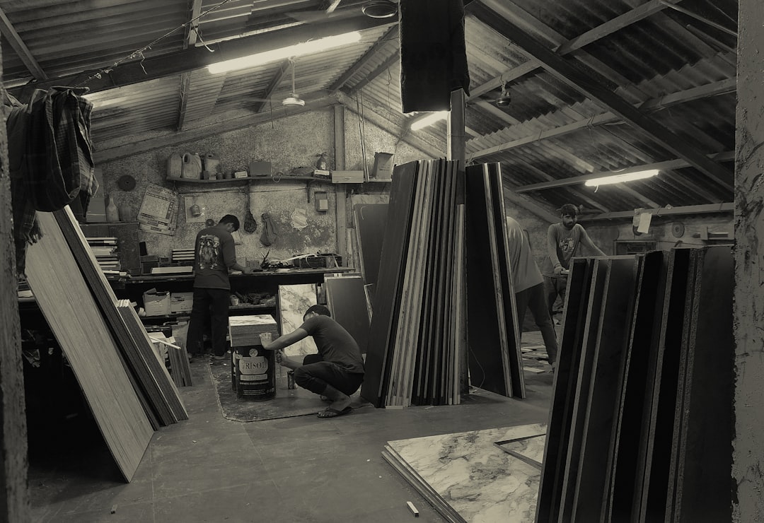 Workers in a workshop with stacked materials.