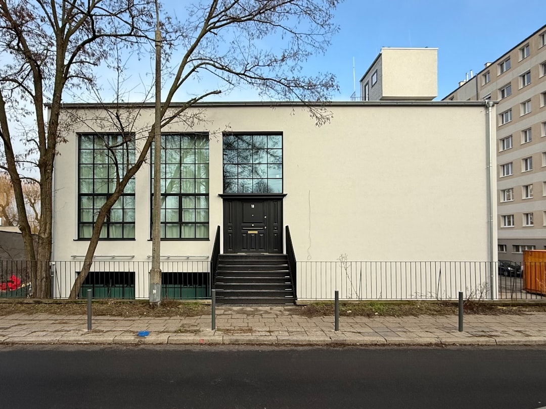 Modern white building with large windows and stairs.