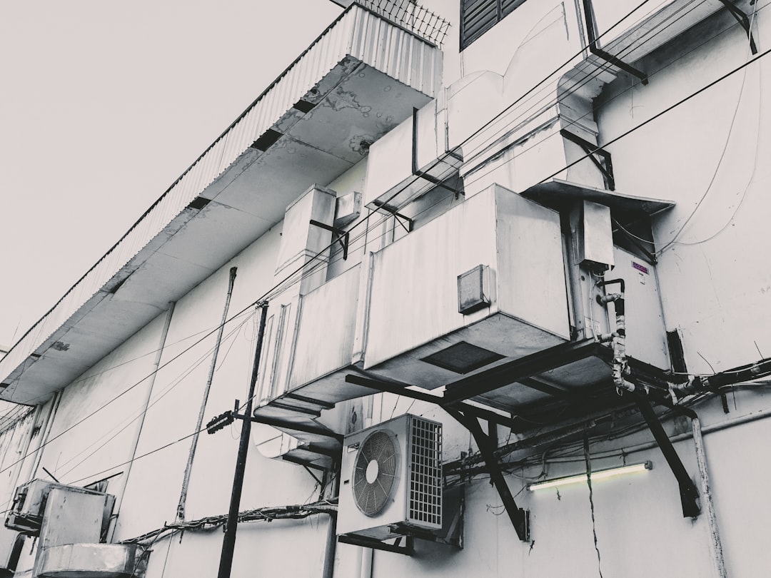 a black and white photo of an air conditioner on the side of a building