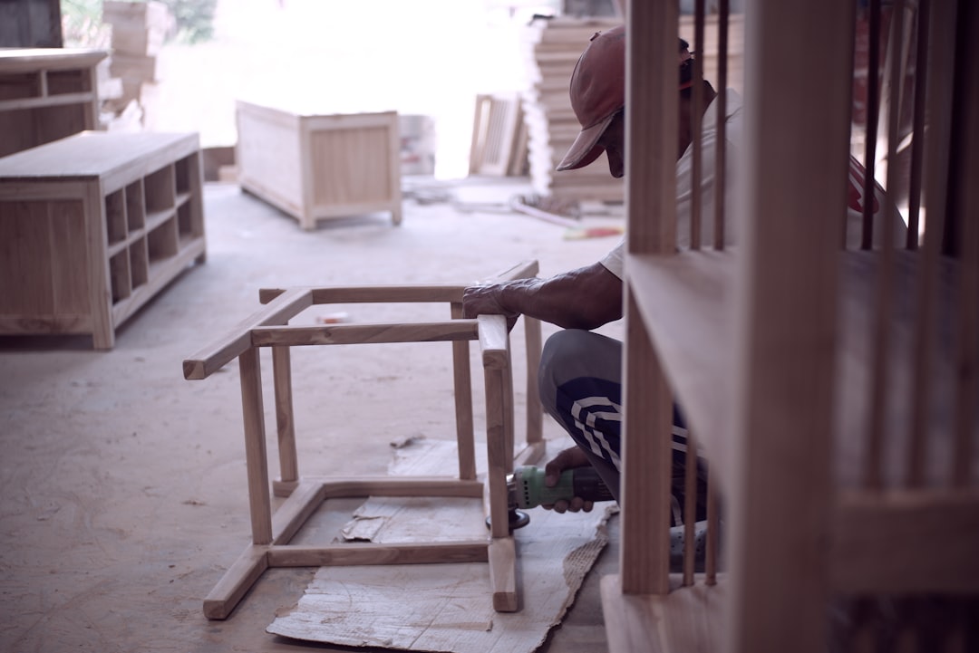 person in black shirt sitting on brown wooden chair