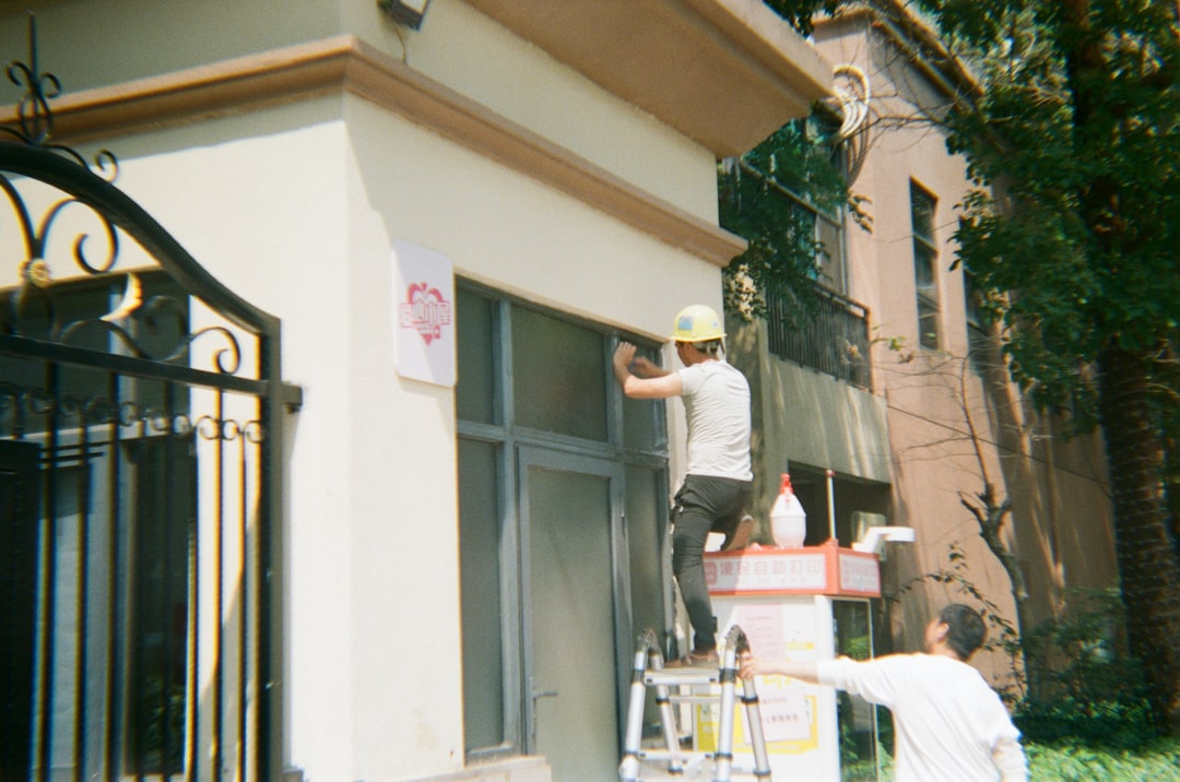 Two men working on a building exterior.