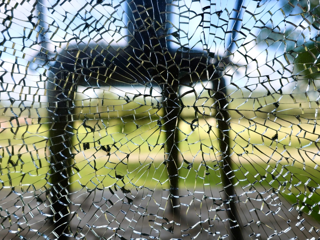 Broken glass obscures a chair in the background.