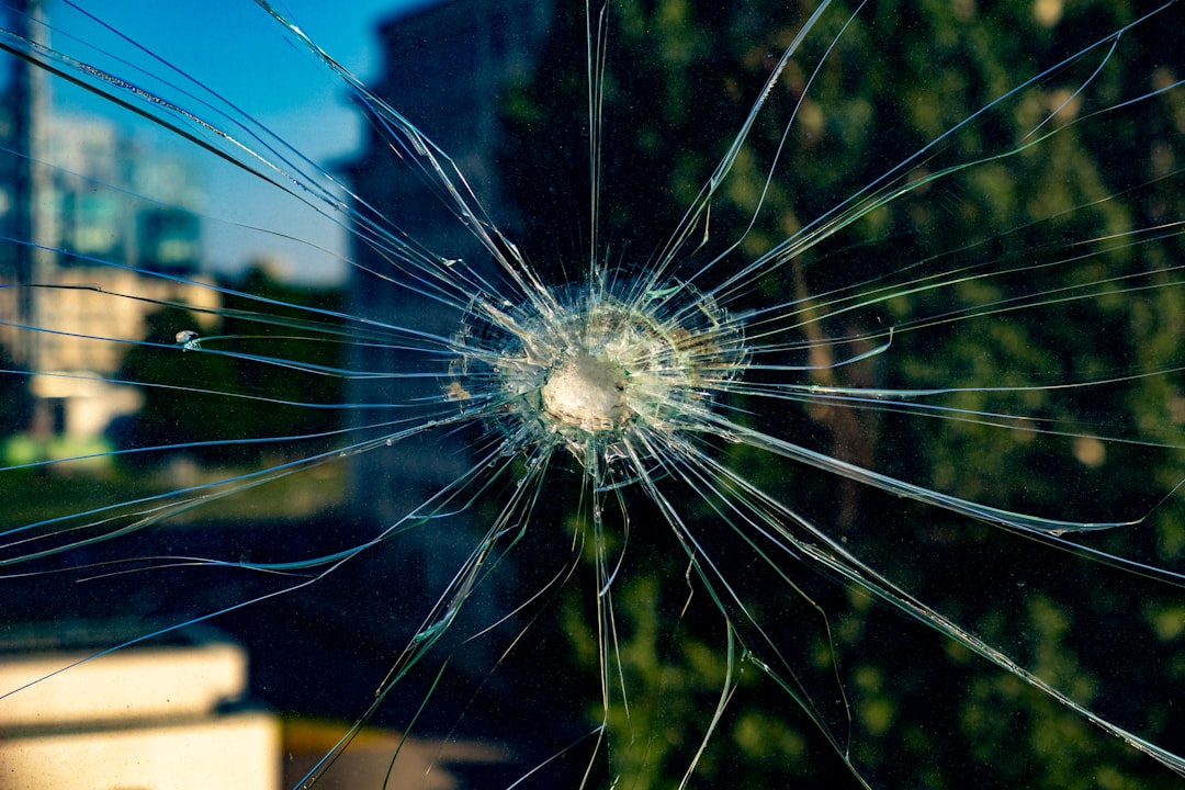 Shattered glass reveals a bullet hole.