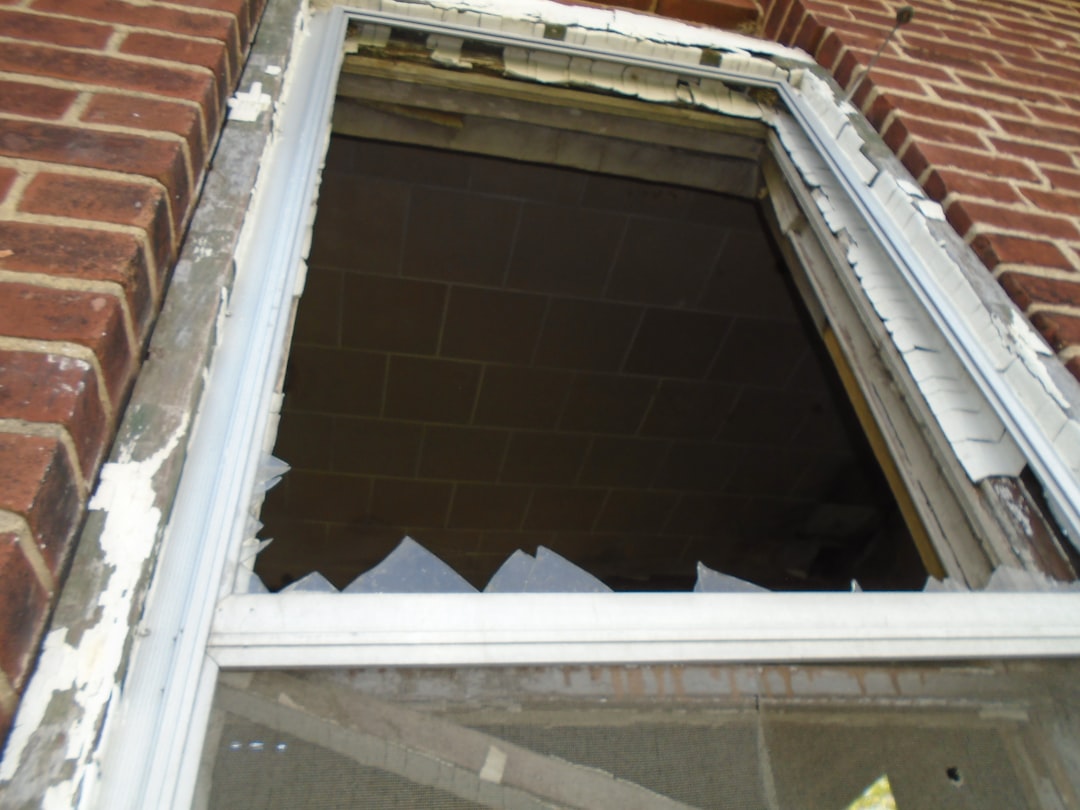 a broken window on the side of a brick building